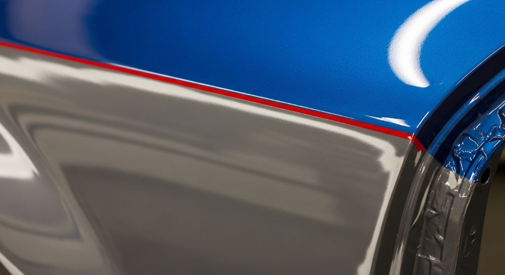 Close-up of smooth automotive paint layering on a car body panel after primer application